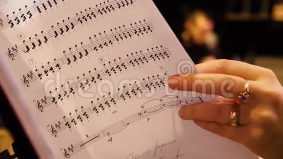美丽的女音乐作曲家看着音乐音符女人看钢琴特写的音符视频的预览图