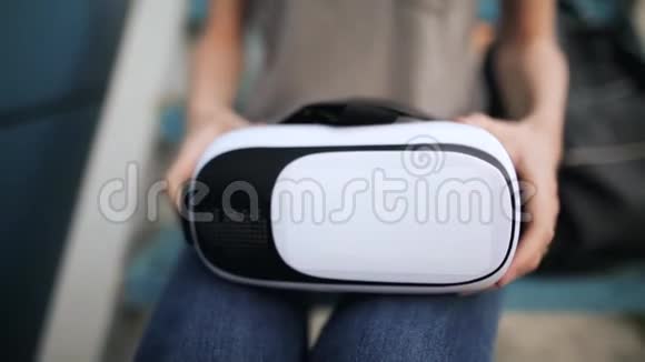 晚上一个小女孩用一只小手在蓝色背景上拿着虚拟现实眼镜蓝色背景视频的预览图