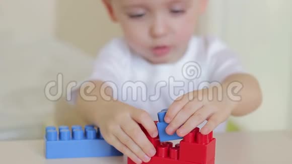 一个男孩在桌子上用彩色积木玩手视频的预览图