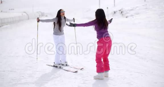 年轻女子教她的朋友滑雪视频的预览图