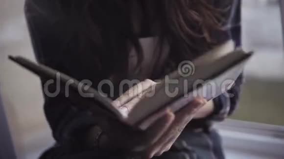 特写镜头一个迷人的高加索女孩读一本书全景拍摄视频的预览图