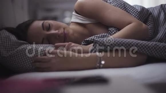 一个熟睡的女人的肖像20多岁的年轻英俊的女人正在床上休息视频的预览图