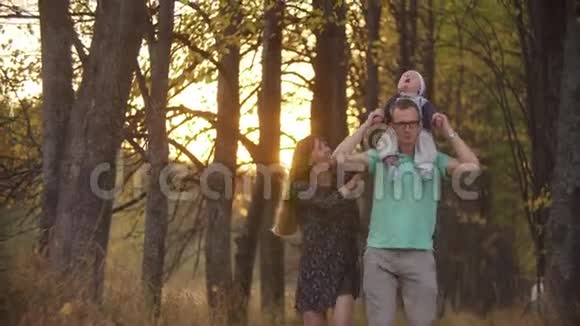 一家三口的镜头在公园里合拍父亲把儿子抱在肩上幸福家庭视频的预览图