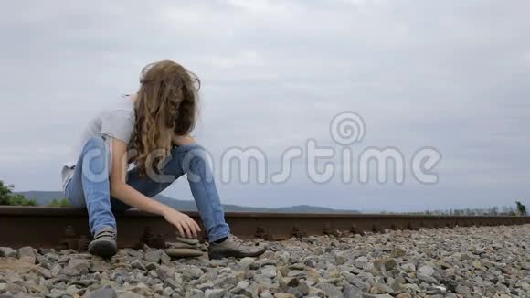 坐在铁路户外的十个年轻悲伤女孩的画像视频的预览图
