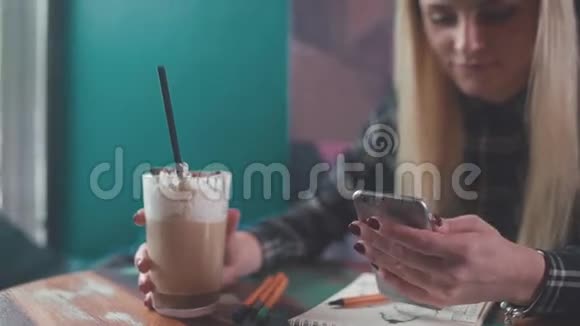 时尚女孩在咖啡店喝咖啡打短信视频的预览图