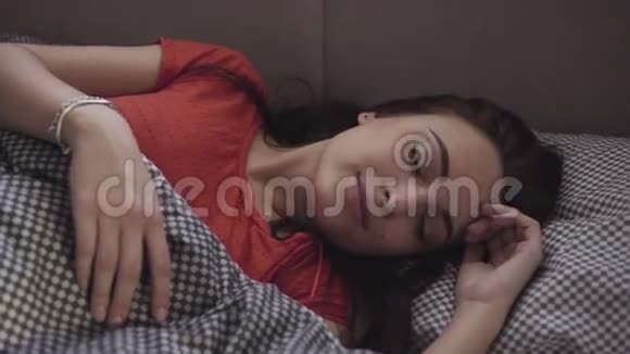 一个睡后正在床上伸展身体的英俊女孩的慢镜头视频的预览图