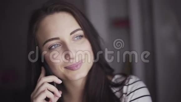 慢镜头的年轻快乐的白种人妇女谈论她的移动设备视频的预览图