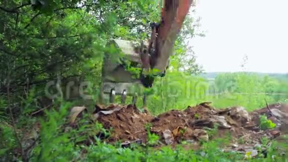 挖土机的铲斗用碎片挖地面视频的预览图
