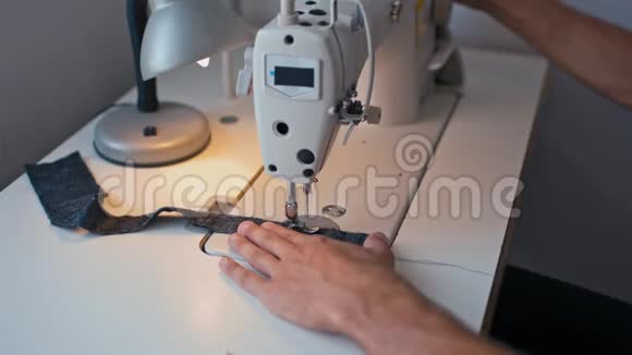 裁缝手在缝纫机上工作在时装设计工作室制造接缝视频的预览图