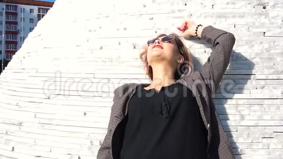 时尚的年轻女模特戴着黑色裙子的太阳镜视频的预览图