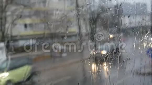 深秋的城市街道上行驶的公共汽车的车窗上突然下起了雨滴和条纹视频的预览图