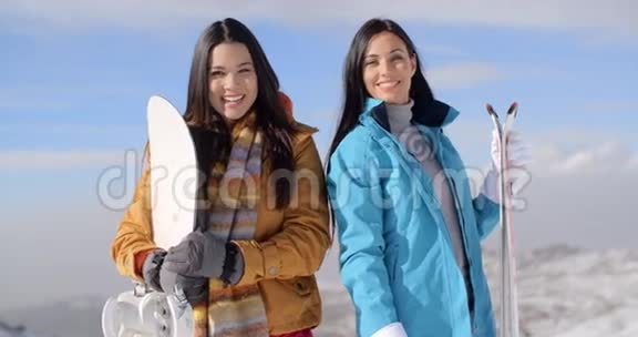 两个漂亮的年轻女人摆着雪板视频的预览图