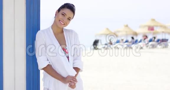 沙滩上穿着白色长袍的快乐美女视频的预览图