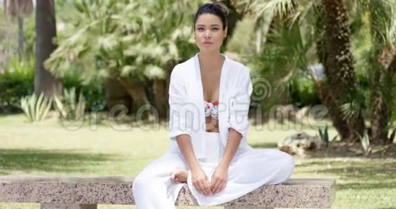 平静的女人独自坐在花岗岩长凳上视频的预览图