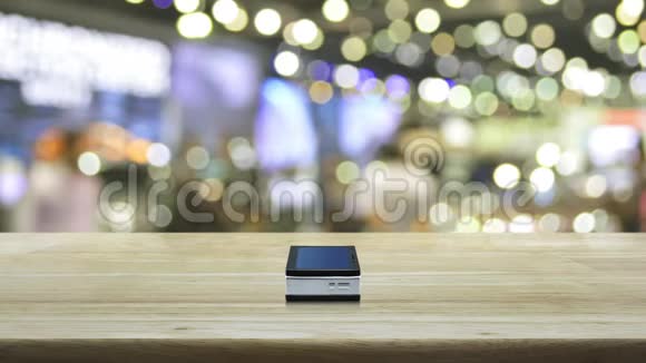 现代智能手机屏幕上的银行平面图标在木制桌子上在购物中心模糊的光影上商业银行o视频的预览图