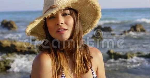 在岩石海岸上快乐美丽的年轻女子视频的预览图