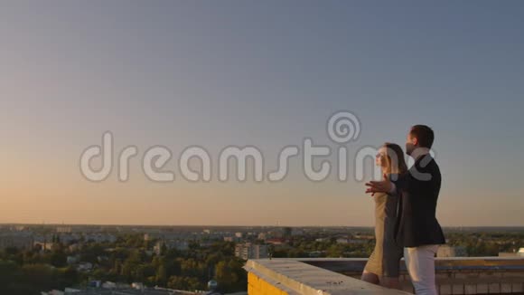 日落时分一男一女拥抱在屋顶上视频的预览图