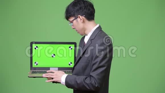 年轻的亚洲商人展示笔记本电脑摄像头视频的预览图