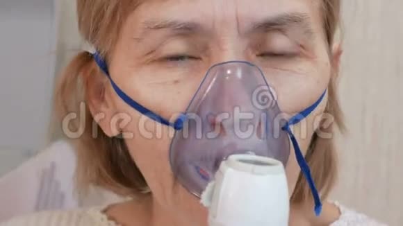 一位在家拿着吸入器面罩的高级妇女通过雾化器治疗气道炎症预防哮喘视频的预览图