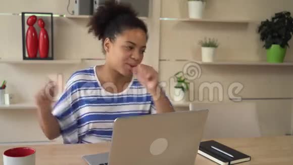 幸福的女人在电脑前的房间里用信用卡跳舞视频的预览图