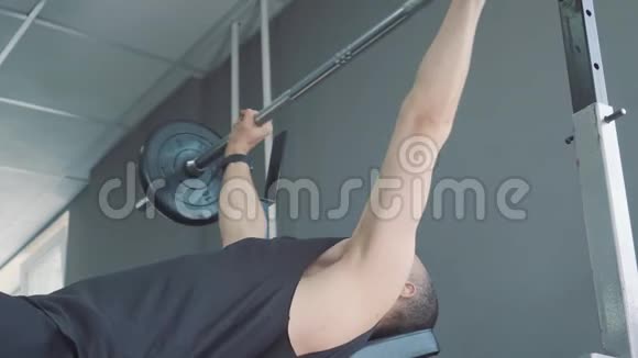 健身房里的哑铃肌肉训练那个人在健身房举起哑铃翻滚的大个子用哑铃训练视频的预览图