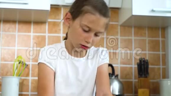 小女孩在厨房的黑桌子上捏面团视频的预览图