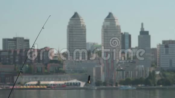 城市背景下河岸上的钓鱼竿视频的预览图