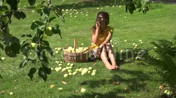 夏天女人坐在果园的草地上吃成熟的苹果4K视频的预览图