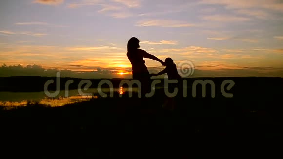 日落时分孩子们和母亲在岸边旋转视频的预览图