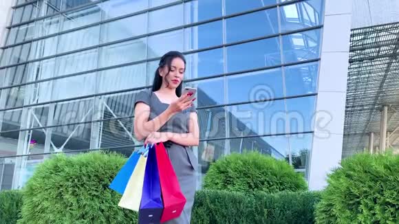 购物在黑色星期五假期一个女人拿着彩色的袋子在她的浅滩购物中心附近视频的预览图