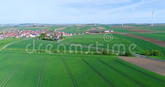 在现代欧洲的一个小村庄附近飞行在风力发电机附近飞行在风力发电机的背景下飞行视频的预览图