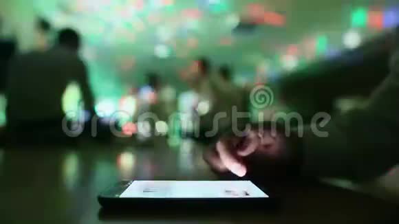 男人在后台滚动电话跳舞的人在聚会上视频的预览图