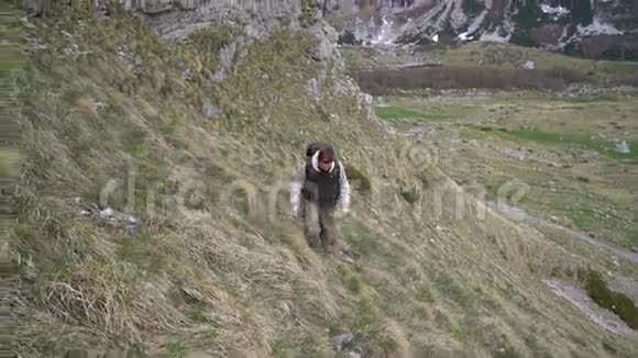 徒步旅行者爬上山坡视频的预览图