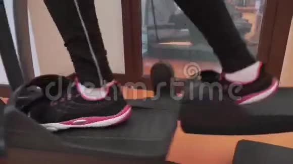 年轻女孩在健身房的椭圆教练训练股票录像视频的预览图