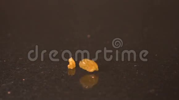 葡萄干慢动作特写镜头黄色葡萄干倒在黑暗的背景上视频的预览图