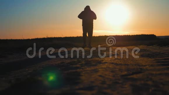 日落时跑步的人的轮廓户外越野跑运动的年轻人在大自然中奔跑视频的预览图