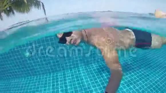 自由潜水水下游泳男人在游泳池里游泳视频的预览图