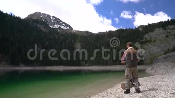 年轻人在风景优美的湖岸上旋转视频的预览图