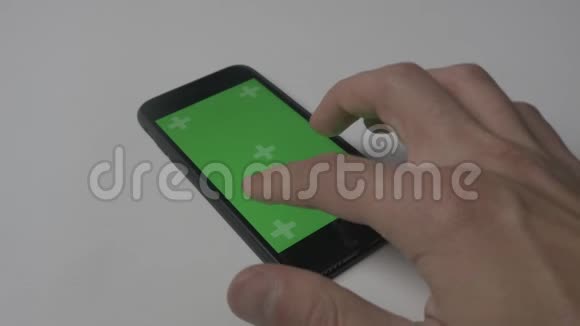 使用智能手机触摸的特写镜头白色桌面背景上有绿色屏幕彩色键视频的预览图
