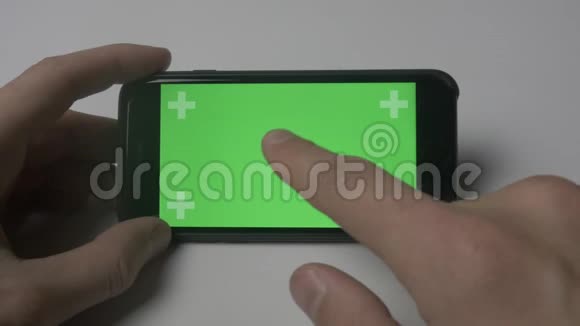 使用智能手机触摸的特写镜头白色桌面背景上有绿色屏幕彩色键视频的预览图