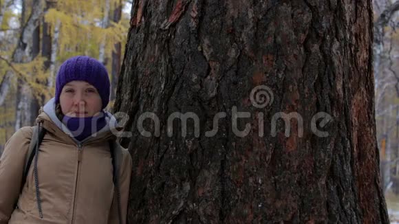 一个女孩的肖像靠近一棵大古树落叶松视频的预览图