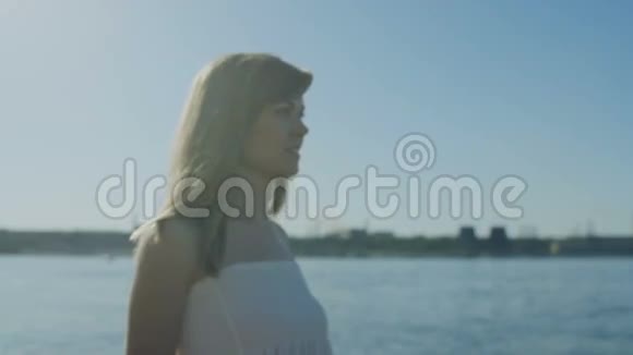 夏天在镇后的海岸线上散步的女人视频的预览图
