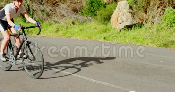 高级骑自行车的人在4k路上骑自行车视频的预览图