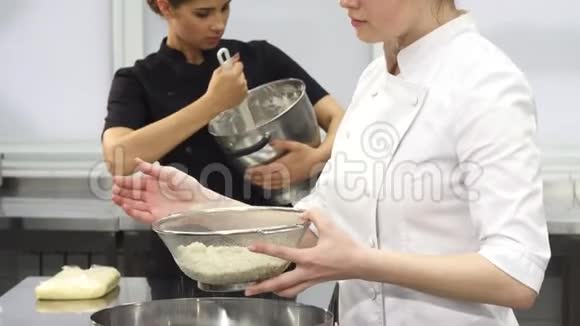 年轻迷人的女厨师一边做饭一边对着镜头微笑视频的预览图