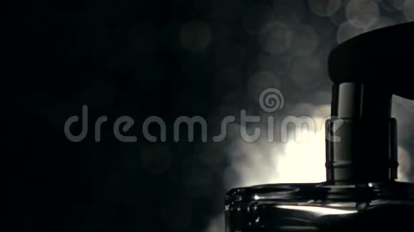 男人在黑暗背景下喷洒香水超级慢镜头视频的预览图