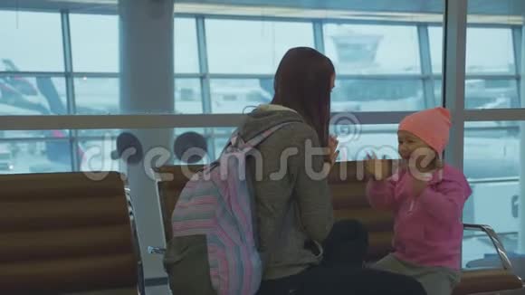 可爱的妈妈和可爱的小女儿在机场慢动作玩得很开心视频的预览图