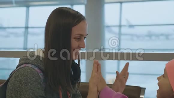 可爱的妈妈和可爱的小女儿在机场慢动作玩得很开心视频的预览图