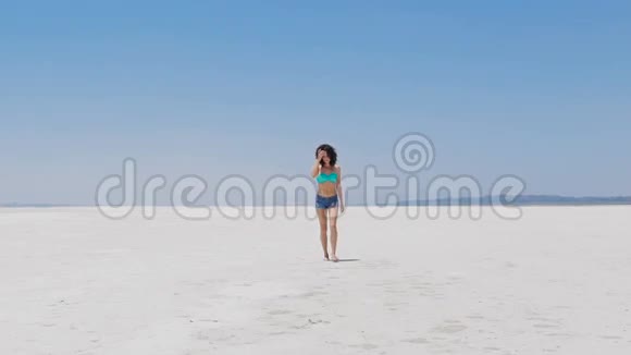 在塞浦路斯一个非常白的盐湖边散步的女人视频的预览图