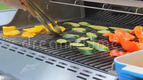 一个人把新鲜蔬菜洋葱西葫芦胡椒放在烤架上特写镜头视频的预览图