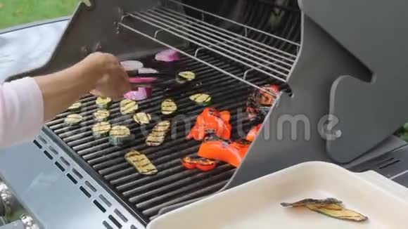 一个人把烤蔬菜洋葱西葫芦胡椒放在盘子里用特写镜头拍摄视频的预览图